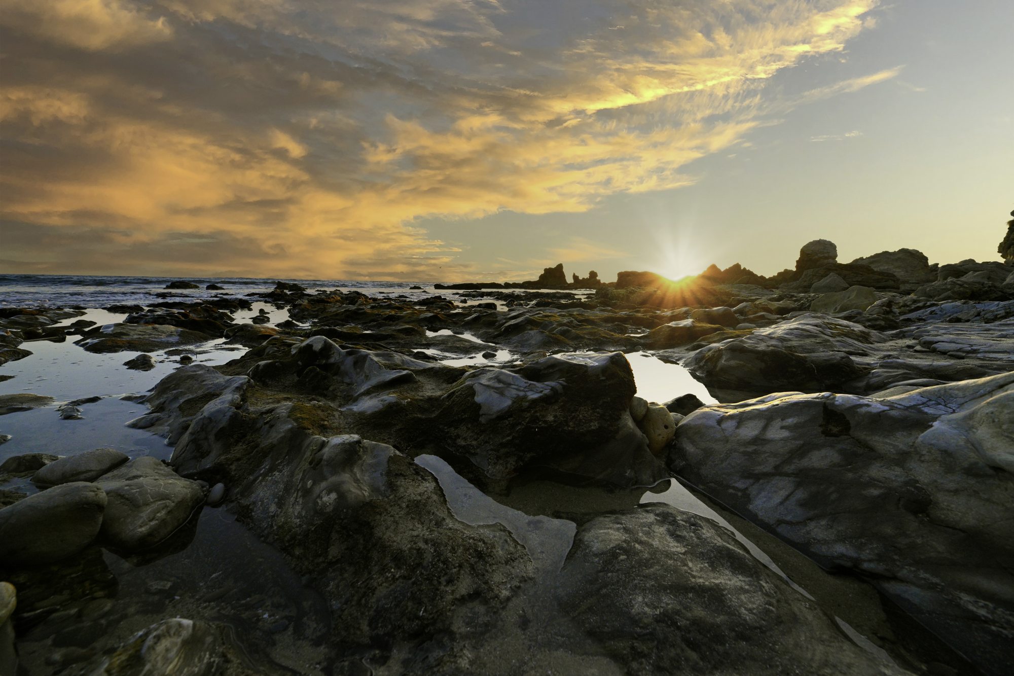 Tide pools, rock and a low sun at sunset, Orange County coast